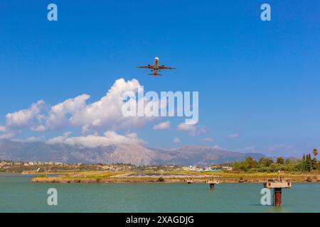 Aereo che atterra sulla costa di Corfù, Grecia. Vista sul mare, sulle colline e sulle case costiere Foto Stock