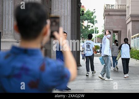 Tianjin, Cina. 7 giugno 2024. Un esaminista va alla sua famiglia in un sito di esami di ingresso al college nazionale a Tianjin, nel nord della Cina, 7 giugno 2024. L'esame di ammissione al college nazionale cinese, noto come Gaokao, è iniziato venerdì. Crediti: Sun Fanyue/Xinhua/Alamy Live News Foto Stock