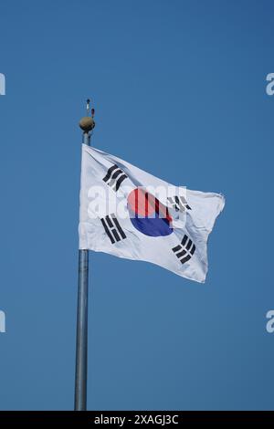 Bandiera nazionale della Corea del Sud che sventola nel vento su sfondo blu del cielo Foto Stock