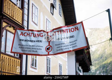 Hallstatt, Austria. 18 maggio 2024. Nel 18.05.2024 a Hallstatt, sul lago Hallstatt, in Austria alta, uno striscione recita in due lingue: "Attenzione - viviamo qui! Goditi la splendida vista in pace, senza urla o musica." può essere letto. Il punto panoramico sul lago Hallstatt è diventato un vero e proprio "punto caldo", attirando innumerevoli turisti ogni giorno. Crediti: Matthias Balk/dpa/Alamy Live News Foto Stock