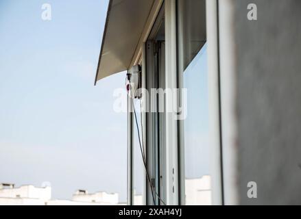 Un moderno robot aspirapolvere lavavetri lavavetri in un appartamento su un balcone. Vista dall'esterno dalla strada. Sicurezza dalle cadute dall'alto, automati Foto Stock