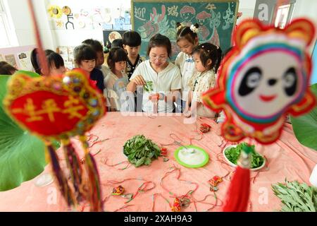 I bambini imparano le usanze popolari del Dragon Boat Festival nella città di Lianyungang, nella provincia cinese di Jiangsu, 4 giugno 2024. Foto Stock