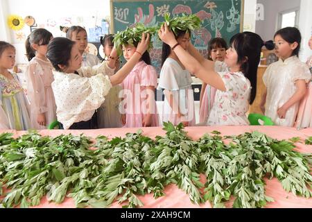 I bambini imparano le usanze popolari del Dragon Boat Festival nella città di Lianyungang, nella provincia cinese di Jiangsu, 4 giugno 2024. Foto Stock