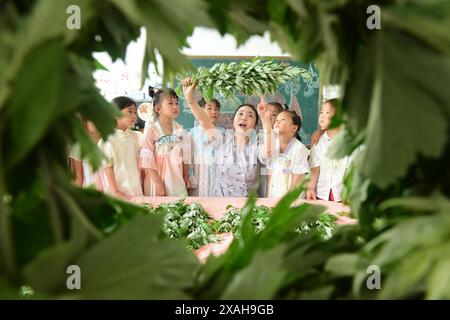 I bambini imparano le usanze popolari del Dragon Boat Festival nella città di Lianyungang, nella provincia cinese di Jiangsu, 4 giugno 2024. Foto Stock