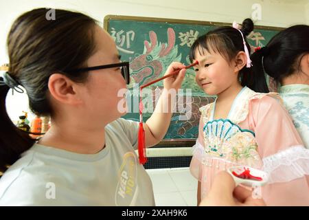 I bambini imparano le usanze popolari del Dragon Boat Festival nella città di Lianyungang, nella provincia cinese di Jiangsu, 4 giugno 2024. Foto Stock