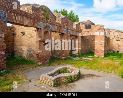 Cortile - Caseggiato del Larario - il complesso, costruito intorno al 120 d.C., fu probabilmente utilizzato per la vendita di beni di lusso come suggerito dalla sua posizione nelle immediate vicinanze del foro e dal suo aspetto particolarmente curato - Parco Archeologico di Ostia Antica, Roma, Italia Foto Stock