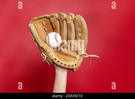 Il guanto da baseball in pelle può contenere il baseball bianco su sfondo rosso. Foto di alta qualità. Vincitore Foto Stock