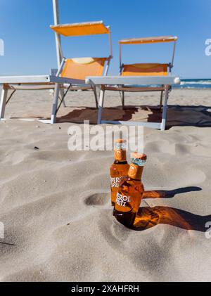 Rimini, Italia, 7 giugno 2024 - due bottiglie Aperol Spritz pronte a bere cocktail sulla sabbia della spiaggia estiva Foto Stock