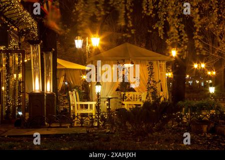 Caffè serale in strada. L'arredamento dei lampioni è bellissimo, le ghirlande si trovano sulla strada nel Garden Cafe. Relax serale al ristorante. Buon divertimento Foto Stock