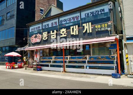 Samcheok City, Corea del Sud - 18 maggio 2024: Un popolare ristorante di granchi al porto di Samcheok, con granchi vivi in vasche e posti a sedere all'aperto, che attira lo Foto Stock