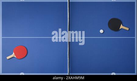 Vista dall'alto della superficie di gioco del ping pong blu professionale con le pale su ciascun lato e la palla. Vista dall'alto. Foto Stock