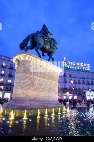 La statua del re Carlo III con il famoso cartello pubblicitario Tio Pepe sullo sfondo nella Puerta del Sol, Madrid, Spagna. Foto Stock