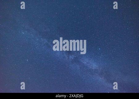 Perditi nella bellezza della via Lattea con questa splendida fotografia. Il cielo notturno è pieno di stelle e costellazioni, rendendolo un ritorno perfetto Foto Stock