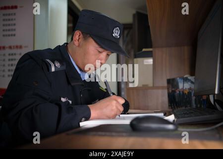 (240607) -- HEFEI, 7 giugno 2024 (Xinhua) -- Ding Ding scrive il "Diario dei pini" nella zona panoramica del monte Huangshan nella provincia di Anhui nella Cina orientale, 4 giugno 2024. Il Guest-Greeting Pine e' un famoso punto di riferimento sul Monte Huangshan. Il pino alto 10 metri, le cui radici sono sgorgate dalle rocce del sito patrimonio dell'umanità dell'UNESCO, si trova a un'altitudine di oltre 1.600 metri. La sua caratteristica più riconoscibile è un lungo ramo che si estende come un braccio allungato in un gesto accogliente. Negli anni '1980 è stato creato un post per supervisionare il Pine Guest-Greeting, responsabile della cura quotidiana e dell'osservazione del Th Foto Stock