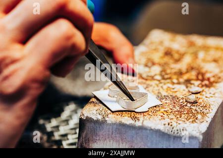 Primo piano di gioiellieri che realizzano due impostazioni dell'orecchino con lunetta Foto Stock