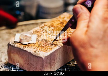 Primo piano di mani dei produttori di gioielli durante la saldatura Foto Stock