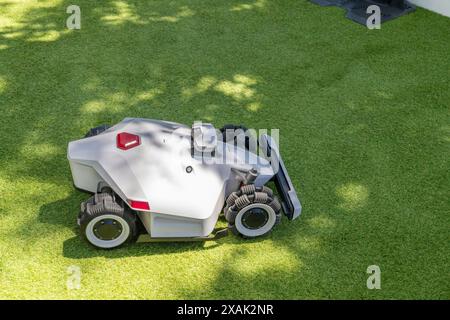 Rasaerba robotizzato autonomo su un campo verde Foto Stock