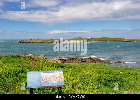 L'isola di Lihou è stata tagliata all'alta marea e l'insegna informativa dal promontorio di l'Eree. Baliato di Guernsey, Isole del Canale, Regno Unito, Gran Bretagna Foto Stock