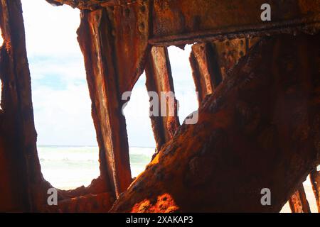 Rusty pezzo sbriciolato del relitto della SS Maheno metà sepolto nella sabbia della spiaggia di 75 miglia sulla costa orientale di Fraser Island nel Queensland, Austra Foto Stock