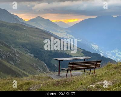 Europa, Austria, Verwall, Tirolo, Kappl, panchina di fronte al Niederelbehütte con vista sulla Sessladtal al tramonto Foto Stock