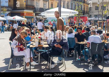 Valencia, Spagna - 24 marzo 2024: Le persone mangiano al ristorante seduti fuori ai tavoli Foto Stock