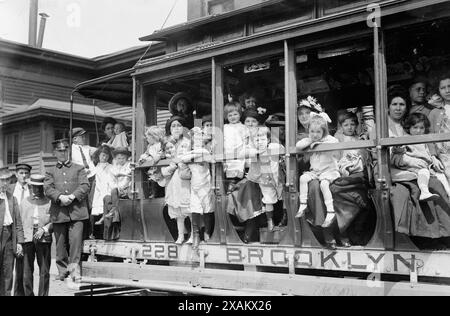 Uscita aria fresca, 1913. Probabilmente mostra le madri e i loro figli in un tram diretto al traghetto che li ha portati a Sea Breeze, Coney Island, in un viaggio sponsorizzato dalla Fresh Air Home della New York Association per migliorare le condizioni dei poveri. Foto Stock