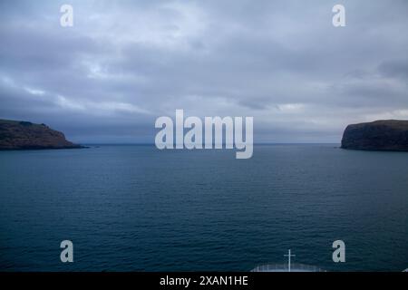 Vista dalla parte anteriore di una nave che naviga lungo un fiordo in nuova Zelanda con acque ancora calme Foto Stock