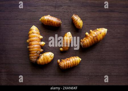 gruppo di radici di curcuma fresche su una superficie di legno Foto Stock