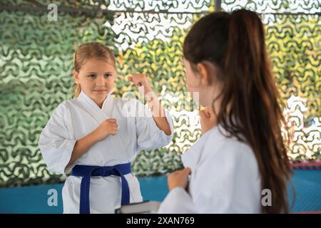 Bambini in kimono praticare karate su tatami all'aperto Foto Stock