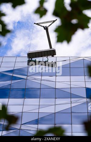 Persone che lavorano insieme all'aperto puliscono finestre su alti edifici, con sfondo blu nuvoloso del cielo, Melbourne Australia. Foto Stock