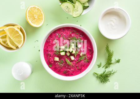 Zuppa di barbabietole fredda estiva nel recipiente su sfondo verde. Disintossicazione sana o concetto di cibo vegetariano. Vista dall'alto, disposizione piatta Foto Stock