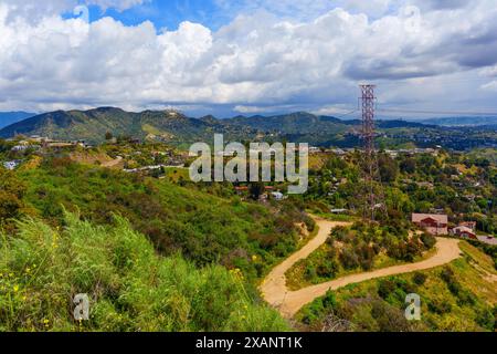 Los Angeles, California - 5 aprile 2024: Quartiere residenziale situato tra lussureggianti colline verdi nelle vicinanze dell'insegna di Hollywood. Foto Stock