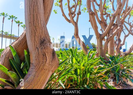 Los Angeles, California - 8 aprile 2024: Cartello d'ingresso LAX immerso in un lussureggiante paesaggio verde. Foto Stock