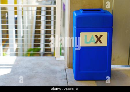 Los Angeles, California - 9 aprile 2024: Cestino dei rifiuti blu brillante nel parcheggio dell'aeroporto internazionale di Los Angeles (LAX), simbolo della pulizia e dell'ordine nella struttura. Foto Stock