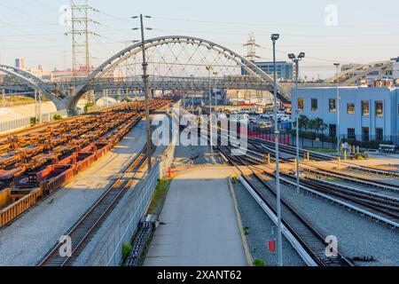 Los Angeles, California - 12 aprile 2024: Magazzini e vagoni ferroviari nell'area industriale sotto il 6th Street Bridge Foto Stock