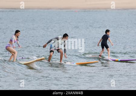 (240608) -- SANYA, 8 giugno 2024 (Xinhua) -- i turisti navigano nelle acque della Queen's Bay a Sanya, nella provincia cinese meridionale di Hainan, il 21 maggio 2024. Sanya vanta una costa che offre uno splendido paesaggio costiero tropicale, rendendola una destinazione ideale per le vacanze al mare. Negli ultimi anni, Sanya ha promosso il turismo costiero tropicale per il tempo libero e lo sport. Attività come surf, immersioni, vela e paddle boarding sono fiorite, attirando gli appassionati di sport acquatici sia da lontano che da vicino. Uno dei primi abitanti del villaggio ad abbracciare il surf fu Yang Xingfu. Proveniente da una famiglia di pescatori, Foto Stock