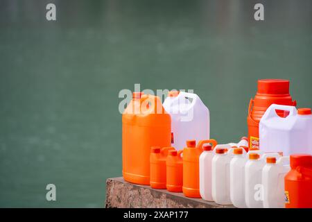 colorate lattine di plastica in zafferano arancione e bianco che mostrano le tradizionali imbarcazioni utilizzate per riempire l'acqua sacra del fiume ganga da portare a casa Foto Stock