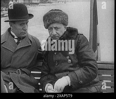 Benito Mussolini (il Duce) e Gabriele D'Annunzio attraversarono il Lago di Garda in Italia in una piccola barca, 1929. Chi e' quello sotto il bocciatore? Amico o nemico? Da "Time to Remember - 1929 The Time of the House at Bognor" - Reel 1; un documentario sul mondo nel 1929. Malattia di re Giorgio V &amp; depressione economica. Foto Stock