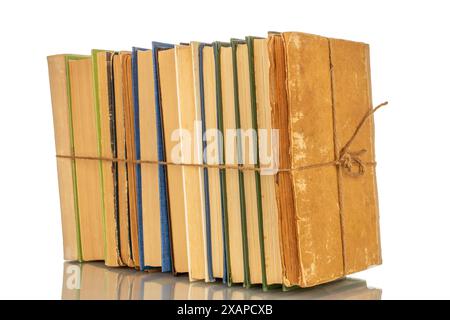 Diversi libri legati con una corda, primo piano su sfondo bianco. Foto Stock