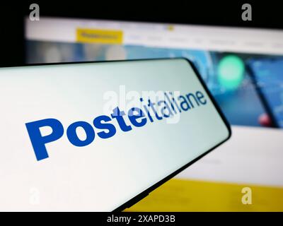 Cellulare con logo della società di servizi postali Poste italiane Spa davanti al sito web aziendale. Mettere a fuoco la parte sinistra del display del telefono. Foto Stock