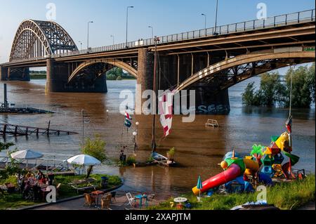 Una parte sotto il ponte è vista sott'acqua. Le persistenti piogge nella Germania meridionale stanno causando un aumento del livello dell'acqua nella zona olandese vicino alla Germania. d. nella città di Lobith, al confine con la Gheldria, è stato misurato un livello di 12,85 metri sopra il piano nazionale di pesca (la base utilizzata per misurare il livello dell'acqua). A Nijmegen, parti basse della banchina e intorno al porto di Waalkade sono sott'acqua. Il livello dell'acqua del Reno ha raggiunto un picco il venerdì mattina, ma era meno alto di quanto inizialmente previsto. L'aspettativa era che l'acqua salisse a più di 13 metri sopra NAP. (Foto di Ana Fernandez/SOPA Foto Stock