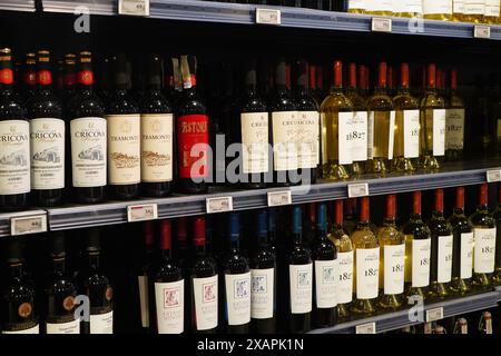 Bucarest, Romania - 23 maggio 2024: Bottiglie di vino rosso e bianco esposte sugli scaffali dell'ipermercato Foto Stock