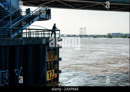 Si vede un uomo che guarda il fiume Waal. Le persistenti piogge nella Germania meridionale stanno causando un aumento del livello dell'acqua nella zona olandese vicino alla Germania. d. nella città di Lobith, al confine con la Gheldria, è stato misurato un livello di 12,85 metri sopra il piano nazionale di pesca (la base utilizzata per misurare il livello dell'acqua). A Nijmegen, parti basse della banchina e intorno al porto di Waalkade sono sott'acqua. Il livello dell'acqua del Reno ha raggiunto un picco il venerdì mattina, ma era meno alto di quanto inizialmente previsto. L'aspettativa era che l'acqua salisse a più di 13 metri sopra NAP. Foto Stock