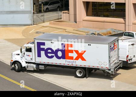 Washington DC, Stati Uniti d'America - 30 aprile 2024: Camion per consegne FedEx Federal Express parcheggiato fuori da un edificio di uffici nel centro della città Foto Stock