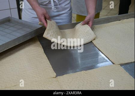 Allstedt, Germania. 8 giugno 2024. L'impasto di lievito per la base della torta di semi di papavero più grande del mondo è collocato sul vassoio da forno della panetteria MEye. Il tentativo record è una campagna della Saxony-Anhalt Art Foundation per celebrare l'anno commemorativo '500 anni della guerra dei contadini e il 500 ° anniversario della morte di Thomas Müntzer nel 2025. Müntzer tenne il suo famoso sermone al castello di Allstedt nel 1524. Crediti: Heiko Rebsch/dpa/Alamy Live News Foto Stock