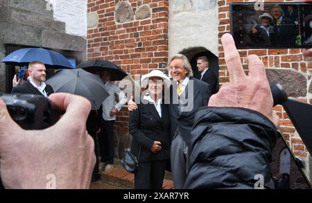 8 giugno 2024, Schleswig-Holstein, Keitum/Sylt: Ospite di matrimonio e imprenditore Manfred Baumann e sua moglie Katharina posero dopo il matrimonio del frontman degli Scooter H.P. Baxxter di fronte alla chiesa di San Severin su Sylt. Non e' stato il primo matrimonio per H.P. Baxxter. Il nativo frisone orientale di Leer, il cui vero nome è Hans Peter Geerdes, è già stato sposato due volte. Foto: Lea Sarah Albert/dpa Foto Stock