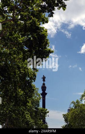 BARCELLONA, SPAGNA - 20 MAGGIO 2024: Il Monumento a Colombo (Monumento a Colón o Mirador de Colón) visto attraverso gli alberi Foto Stock