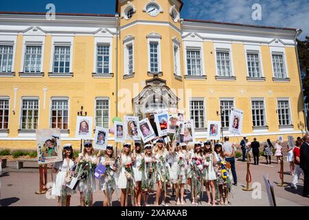 LE RAGAZZE POSANO PER UN QUADRO di GRUPPO, Åland GRADUATION, MARIEHAMN: Un grande gruppo di ragazze laureate posano per un quadro celebrativo con fiori e i loro cartelli per bambini fuori dalla scuola principale, al Åland Graduation Day 2024 presso Åland Lyceum (Ålands Gymnasium) a Mariehamn, Arcipelago di Åland, Mar Baltico, Finlandia – questo è il giorno in cui gli studenti lasciano la scuola per l’ultima volta. Come parte di questa tradizione nordica, i cartelli sono sormontati con foto dei bambini dei laureati e gli studenti stessi indossano i loro cappelli di laurea in stile marinaio (studentmössa) e vestiti in abiti e abiti bianchi. Foto Stock