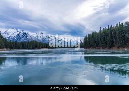 Il lago Johnson ha congelato la superficie dell'acqua in inverno. Montagna innevata sullo sfondo. I turisti qui che praticano il pattinaggio su ghiaccio in questa stagione. Banff Natio Foto Stock