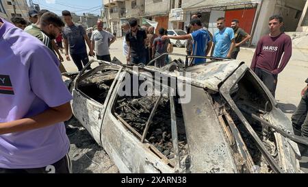 Nuseirat, Gaza. 8 giugno 2024. I palestinesi ispezionano un'auto bruciata distrutta in un'operazione delle forze speciali israeliane nel campo di Nuseirat, nella Striscia di Gaza centrale, sabato 8 giugno 2024. L'esercito israeliano ha detto che quattro ostaggi israeliani sono stati salvati da Gaza durante la missione di salvataggio. Foto di Hatem al-Rawag/UPI credito: UPI/Alamy Live News Foto Stock